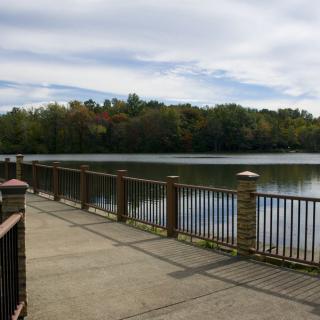 A scenic view of a lakeside pathway with trees in the background.