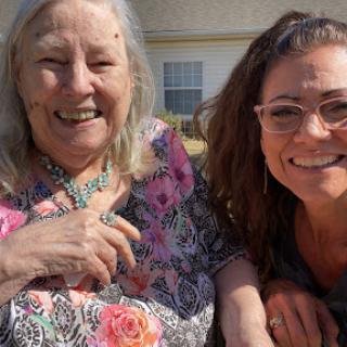A joyful moment captured with a smiling elderly woman and a younger woman enjoying the outdoors.