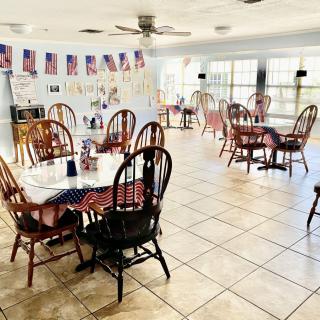 A bright cafe interior with tables and chairs, decorated with small flags.