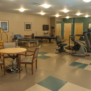 A rehabilitation center with exercise equipment and seating area.