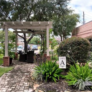 A serene garden setting featuring a pergola, lush greenery, and a cobblestone pathway.