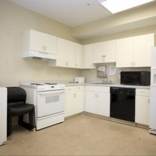 A spacious kitchen featuring white cabinets and essential appliances.