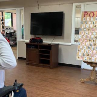 An indoor room with a television, cabinet, and a game board on an easel.