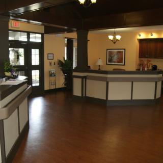 A modern reception area with a welcoming front desk and wooden flooring.