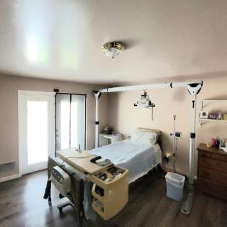 A hospital room with a patient bed and medical equipment, offering a clinical and organized setup.