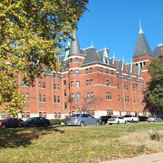A beautifully designed historical brick building with pointed towers, set against a clear blue sky.