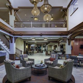 Spacious hotel lobby with elegant chandeliers and comfortable seating.
