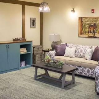 A cozy living room with a patterned sofa, a wooden coffee table, and decorative cushions.