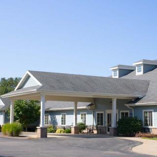 A single-story building with a covered entrance and surrounding landscaping.