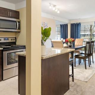 Modern kitchen and dining area with stainless steel appliances and an open floor plan.