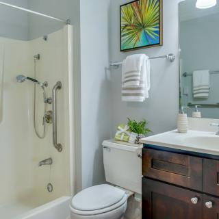 A modern bathroom featuring a shower, sink, and toilet with decorative elements.