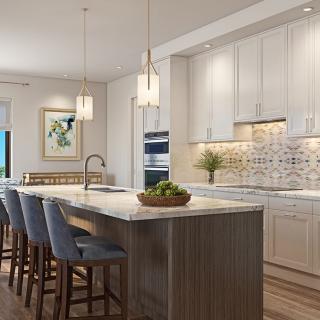 A modern kitchen featuring an island counter with bar stools and pendant lighting.