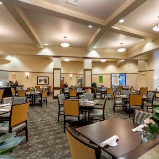 A spacious and well-lit dining room with neatly arranged tables and chairs.