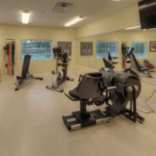 A fitness room equipped with various exercise machines and stationary bikes.