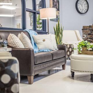 A cozy living room setup featuring a stylish sofa, decorative pillows, and a warm lamp.