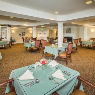 An elegantly set dining room with neatly arranged tables and chairs.