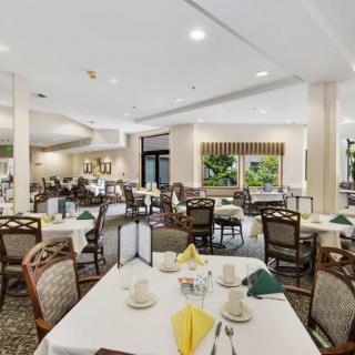 A spacious and elegantly decorated restaurant dining area with neatly arranged tables and chairs.