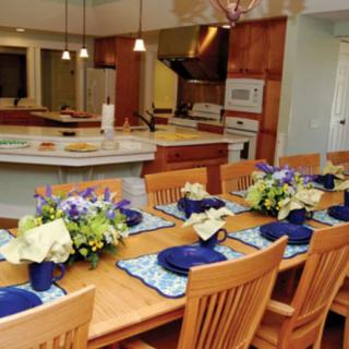 A beautifully set dining table with floral arrangements in a modern kitchen.