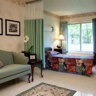 A cozy combined living and sleeping area featuring a couch, bed, and large window.