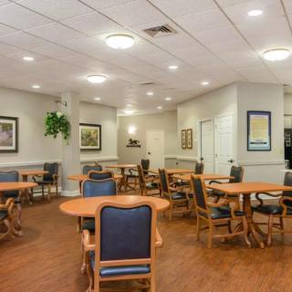 An empty, well-lit dining area with multiple tables and chairs arranged neatly.