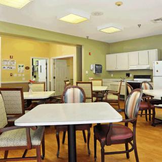 A spacious dining area with tables, chairs, and an adjacent kitchen.