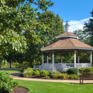 A picturesque gazebo surrounded by lush greenery in a serene park setting.