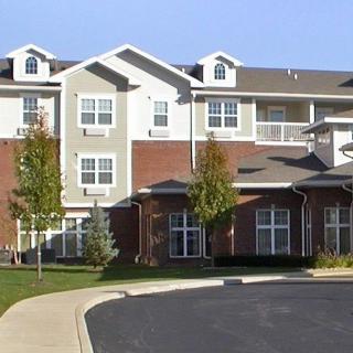 A modern multi-story apartment building with a mix of brick and siding exterior.