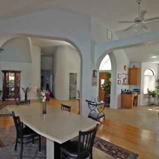 A spacious open-plan interior featuring a kitchen and dining area with high ceilings.
