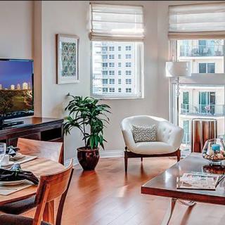 A modern living room in an apartment with natural light, featuring contemporary furniture and a window view.
