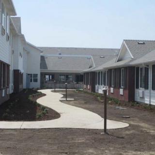 A view of a newly constructed building complex with a central pathway.