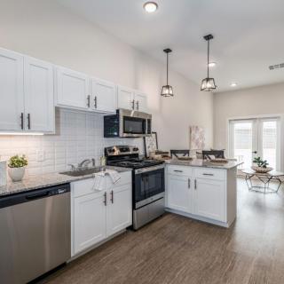 A modern kitchen with white cabinets and stainless steel appliances.