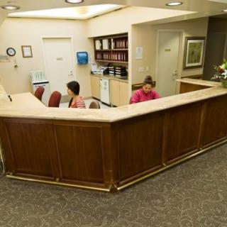 A reception area with a curved desk and two employees working behind it.