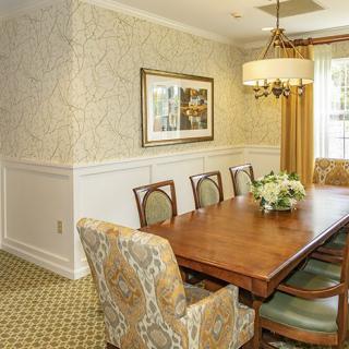 Elegant dining room with a wooden table, upholstered chairs, and decorative lighting.
