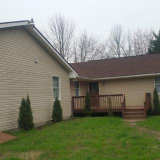A suburban house with a front porch and green yard.