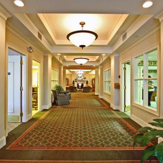 A well-lit hallway with decorative lighting and patterned carpet.