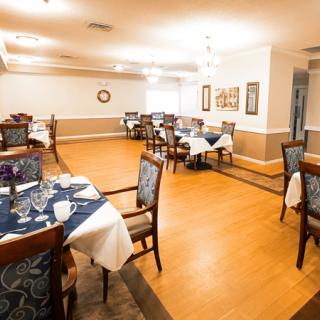 A well-lit dining room with neatly arranged tables and chairs, showcasing an inviting restaurant interior.