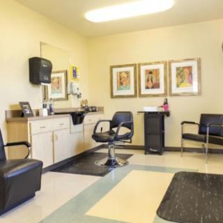 A well-lit hair salon with chairs and artwork on the walls.