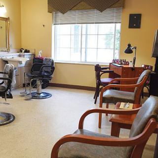 A cozy salon with chairs, mirrors, and a well-lit waiting area.