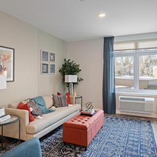 A modern living room with a comfortable sofa, decorative pillows, a coffee table, and artwork on the walls.