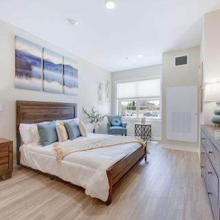 A modern bedroom with elegant decor, featuring a wooden bed and natural lighting.