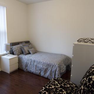 A minimalist bedroom with a bed, nightstand, and simple decor.
