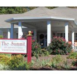 Entrance of The Summit building with a landscaped garden and a sign in front.