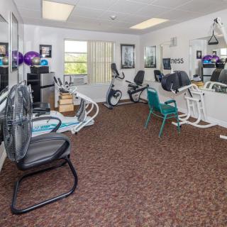 A small gym room equipped with exercise bikes and mirrors.