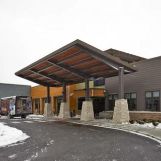 A modern building entrance with a large canopy and snow-covered surroundings.