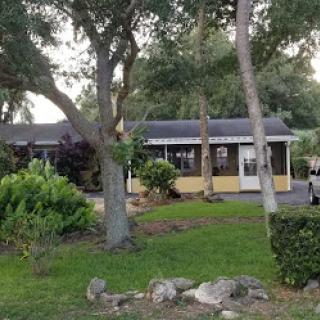 A charming residential house surrounded by lush greenery and well-kept landscaping.