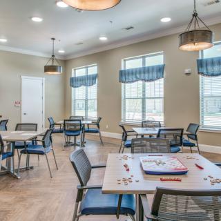 A well-lit community room with tables set up for games and activities.