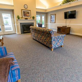 A spacious living room with comfortable sofas, a fireplace, and a television.