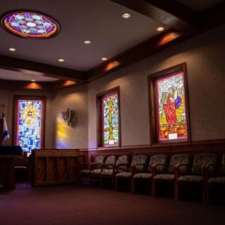 A serene church interior with stained glass windows and rows of seating.
