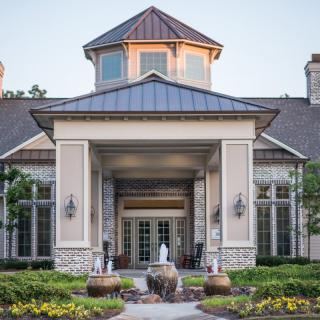A grand entrance to a beautifully designed building with landscaped surroundings.