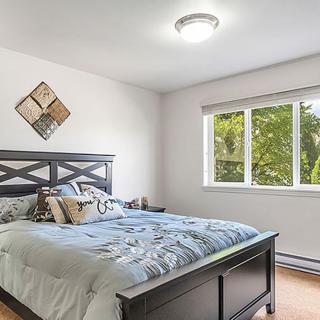 A cozy bedroom with a large bed, decorative wall art, and a window letting in natural light.